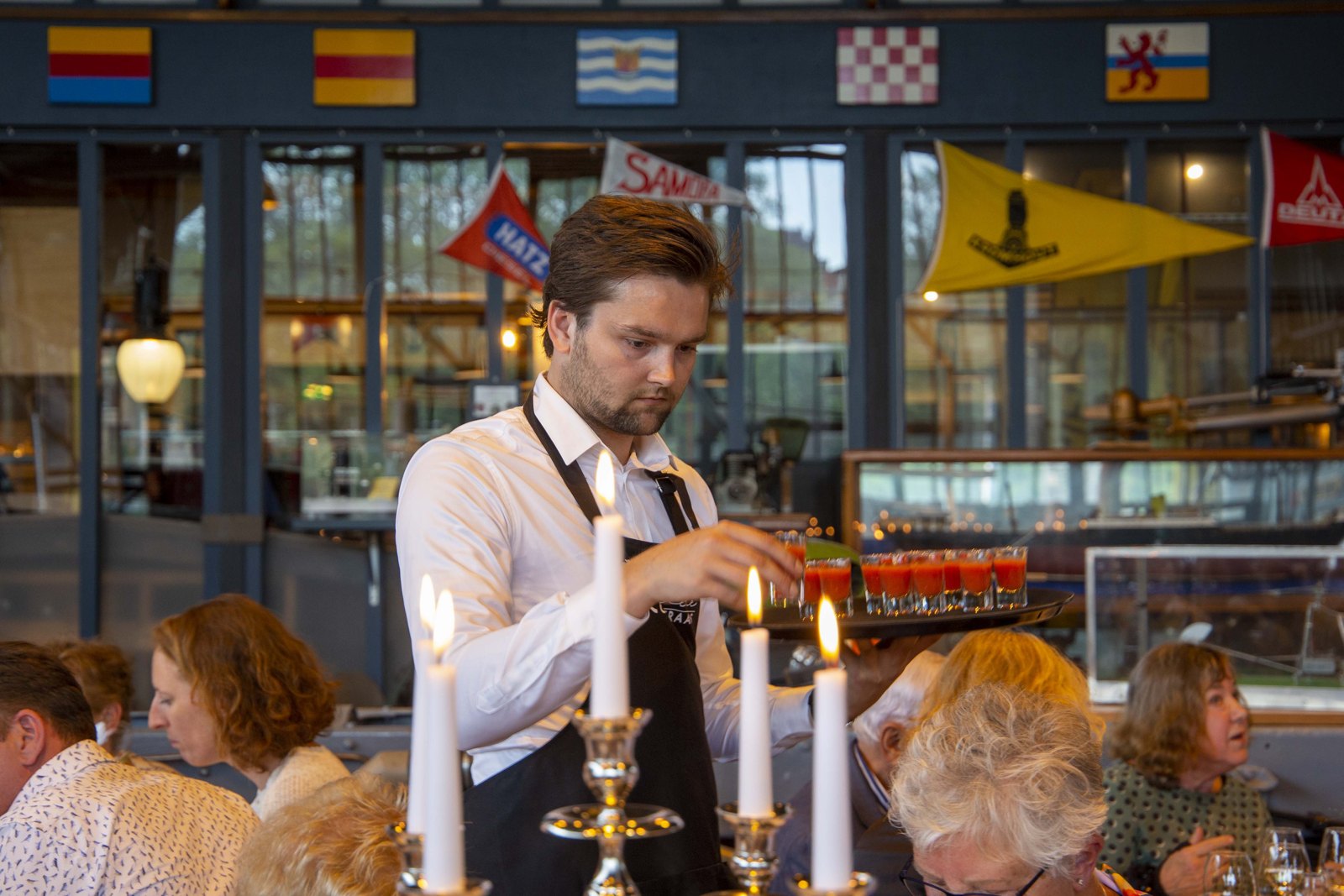 Bediening steekt kaarsen aan bij een diner