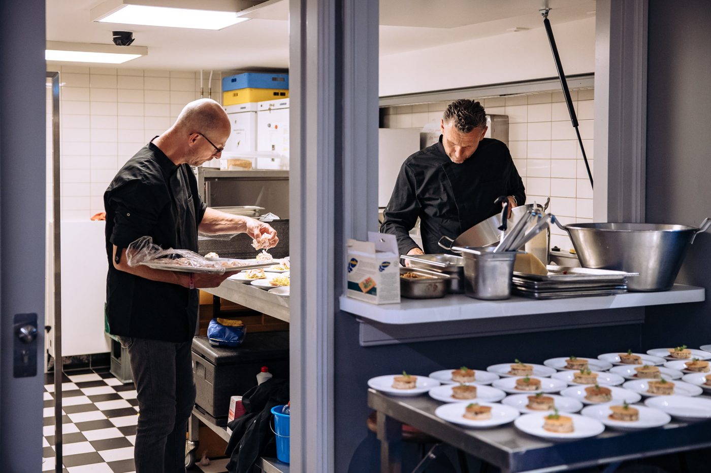 Twee koks bereiden borden in de keuken